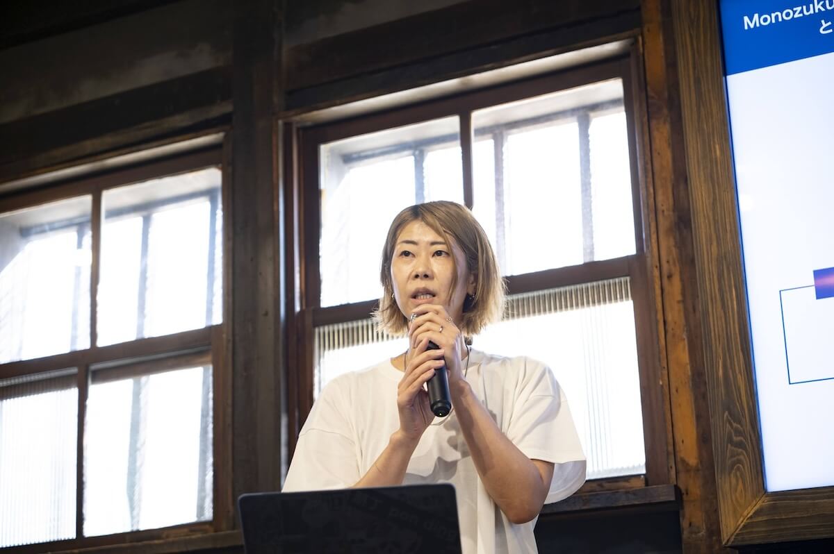 女性がマイクを持ち、登壇者として話している様子