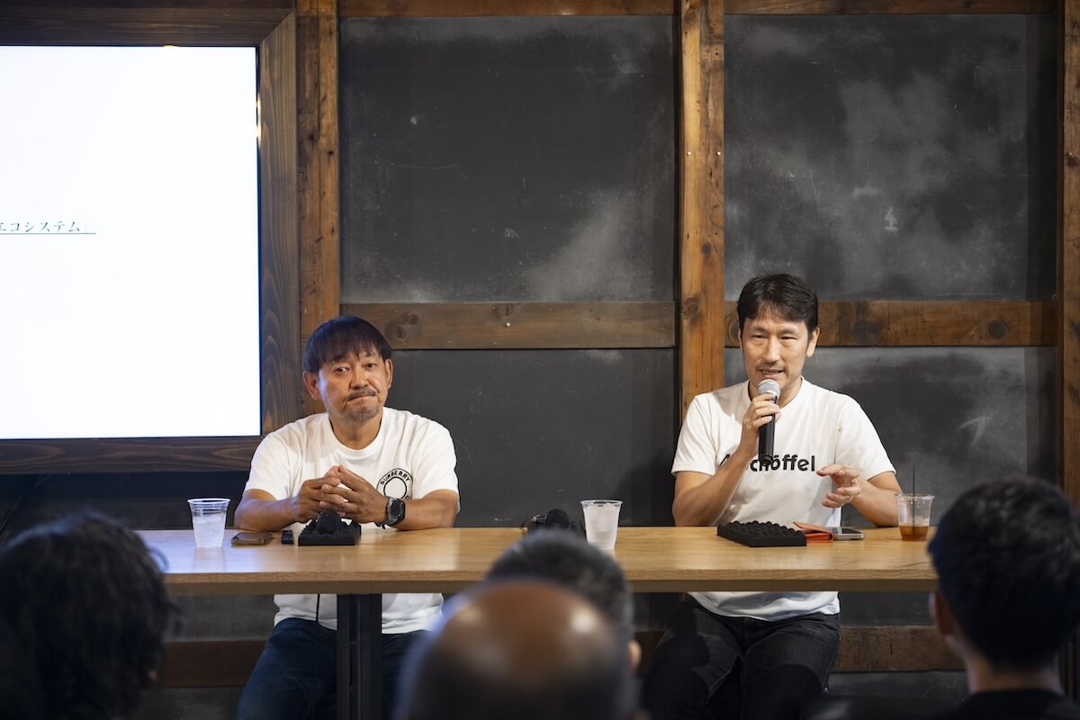 二人の男性が長机につき、登壇者として話している様子