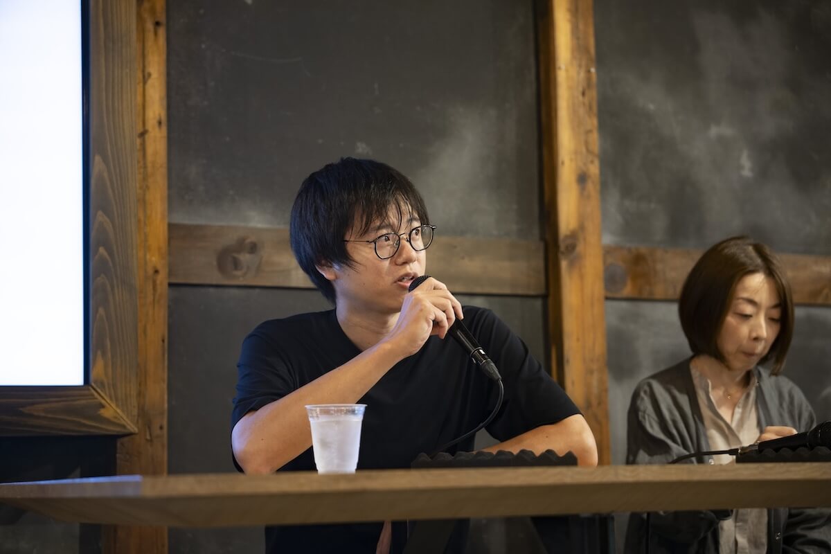 男性がマイクを持ち、観客に向けて話している様子